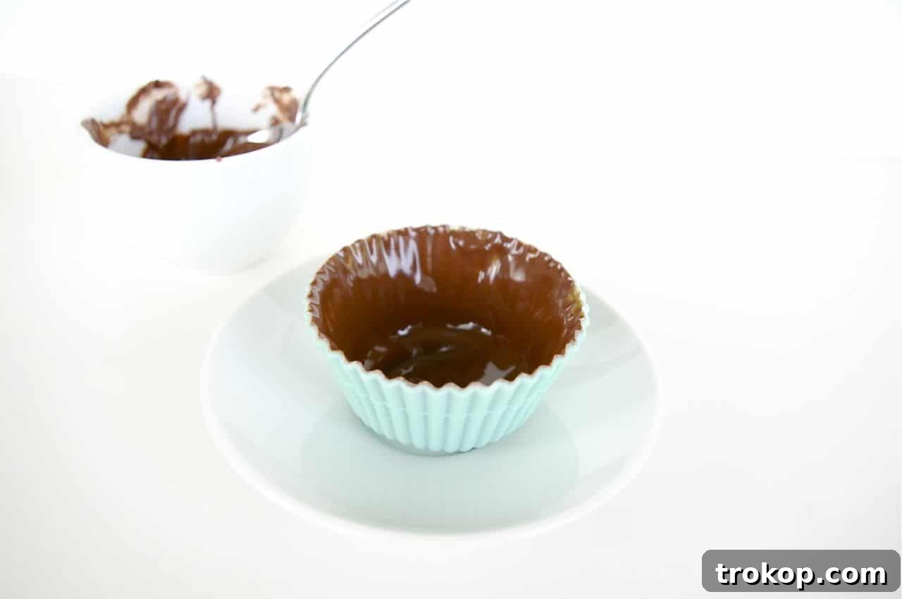 Preparation step for chocolate cupcake liners: melted chocolate in silicone molds.