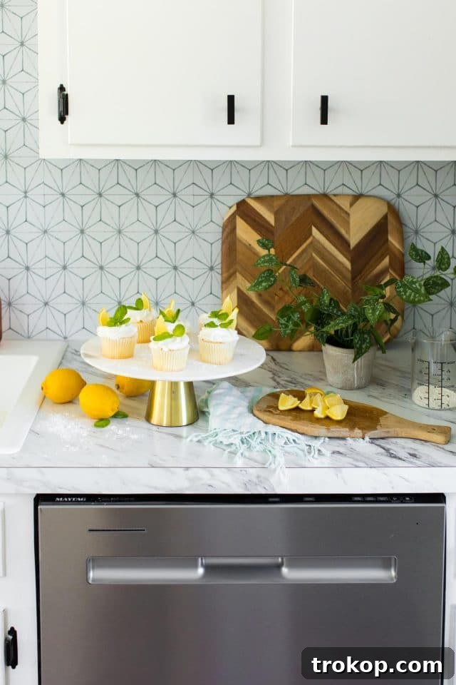 Tangy Lemon Cupcakes with Zesty Citrus Frosting 6 photo of the lemon cupcakes being garnished in the kitchen by top Houston lifestyle blogger Ashley Rose of Sugar & Cloth