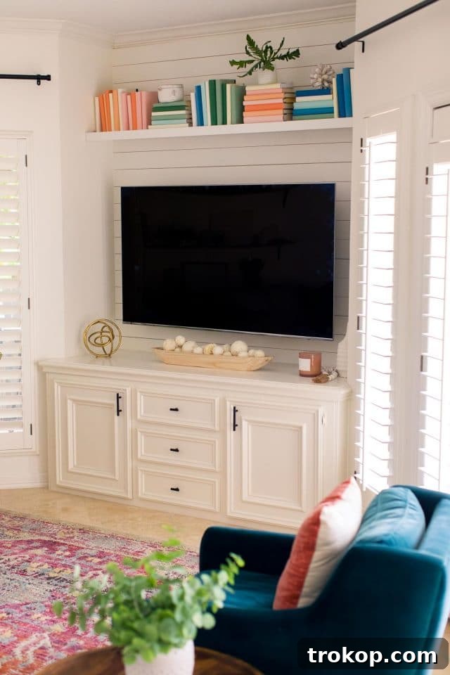 Clean and modern TV area with floating shelf and subtle decor in the family room.