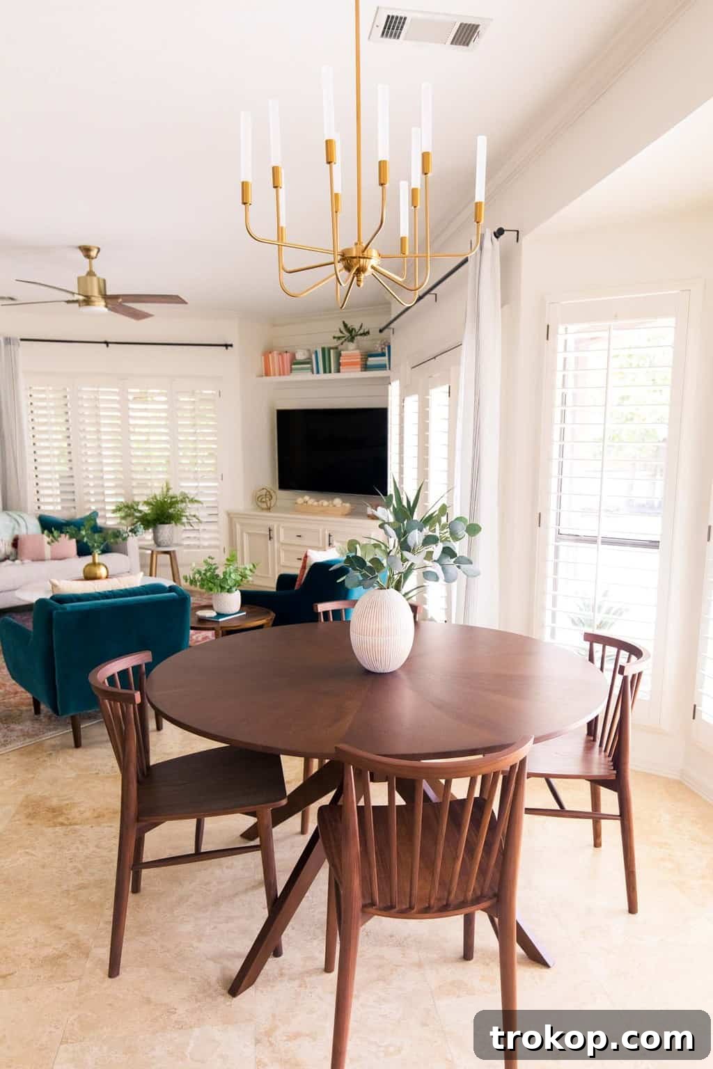 Open concept living area with a stylish dining table and a glimpse of the refreshed family room beyond.