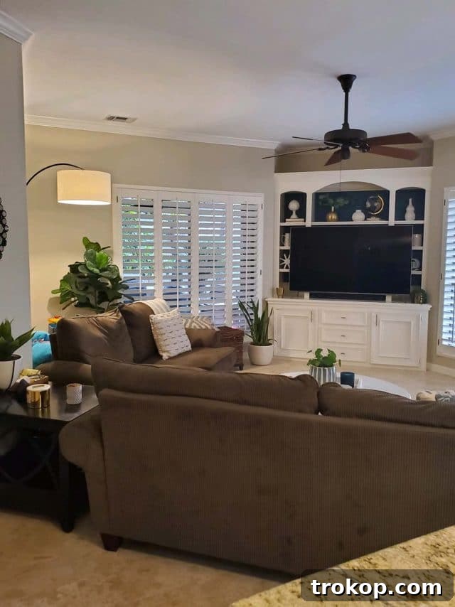 Before photo of a dark, traditional living room with heavy furniture and muted tones.