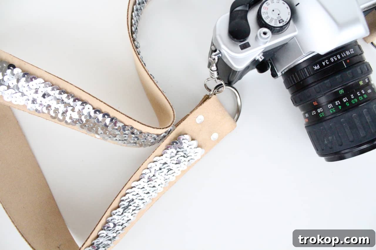 All materials laid out for making a sequin camera strap: leather, sequins, rivets, tools