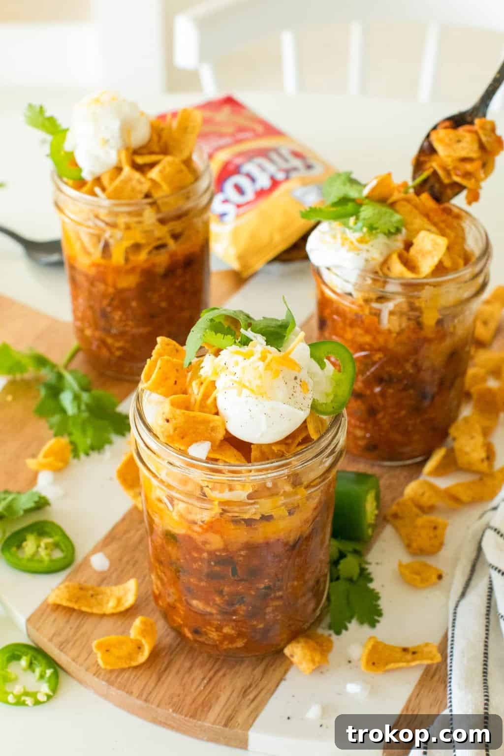 On-the-Go Frito Pie Jars 4 photo of the frito pie mason jars garnished with sour cream, onions and jalapeños by top Houston lifestyle blogger Ashley Rose of Sugar & Cloth