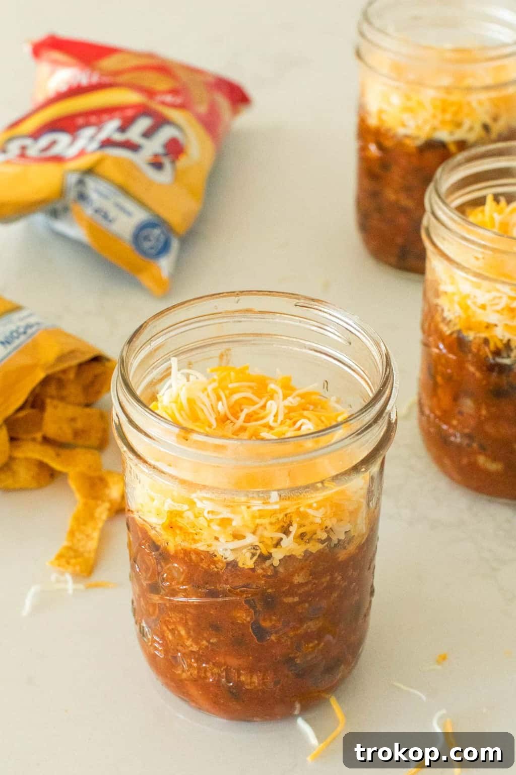 On-the-Go Frito Pie Jars 6 photo of the frito pie being assembled in a mason jar by top Houston lifestyle blogger Ashley Rose of Sugar & Cloth