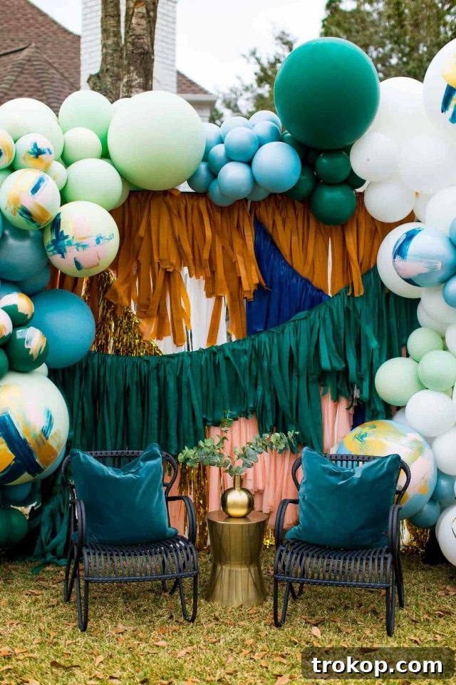 Your Essential Guide to a Drive-Thru Baby Shower 10 Two stylish black outdoor chairs positioned in front of a vibrant party backdrop adorned with a large balloon arrangement for a drive-thru shower