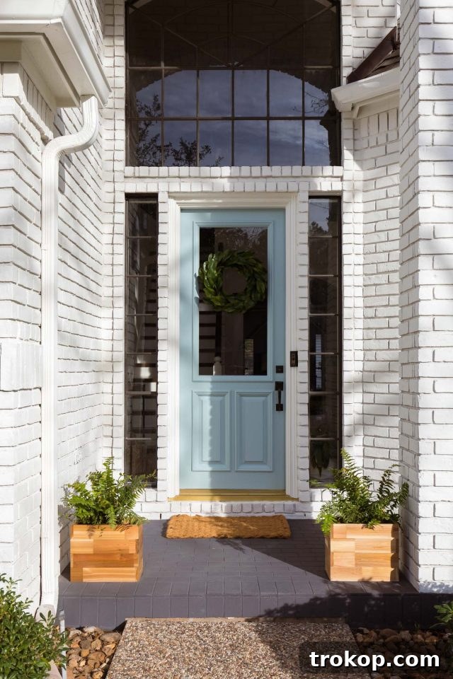 a limewash painted brick front porch and white brick exterior creating a cohesive look