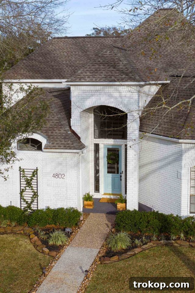 an angled drone photo of an exterior white house with limewash accentuating its architectural details