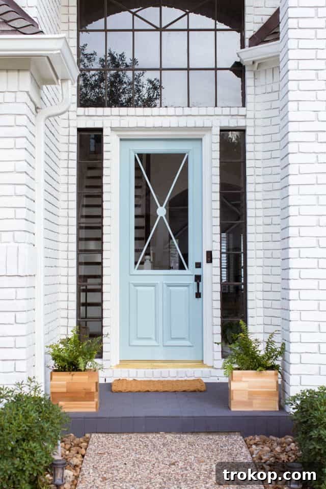 photo of an updated front porch and blue door complemented by limewash brick