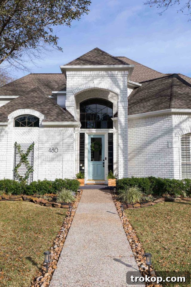 entrance of a white house exterior with a blue door, elegantly finished with limewash paint