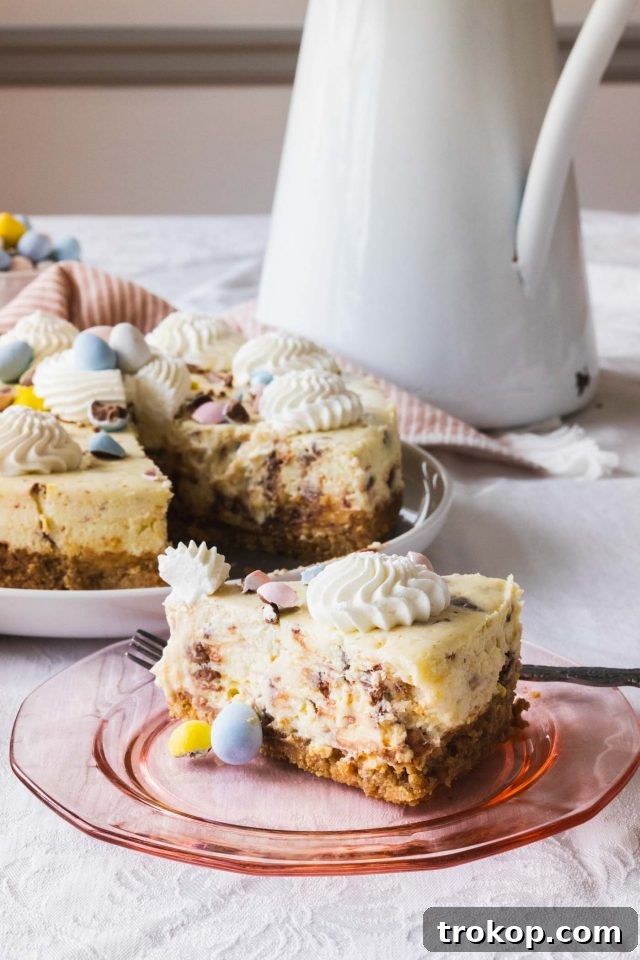 An exquisitely decorated Easter Egg Cheesecake featuring an array of Cadbury eggs, making it an ideal festive dessert