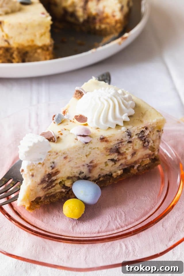 A perfectly sliced piece of mini egg cheesecake, showcasing its creamy texture and the embedded mini Cadbury egg pieces
