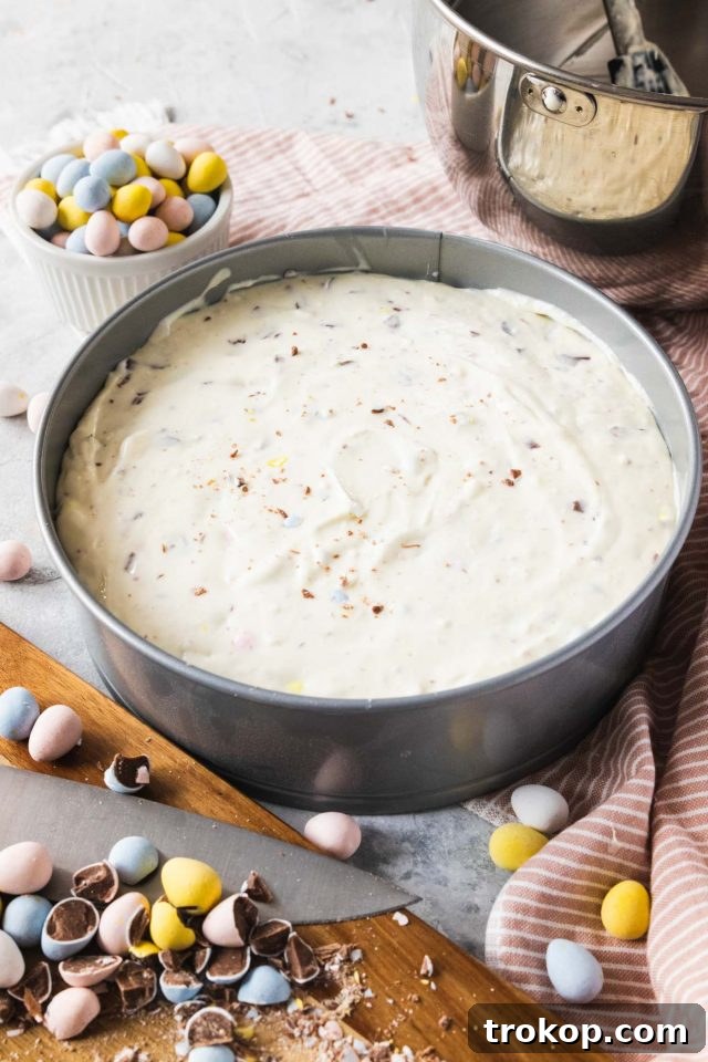 The Easter Egg Cheesecake, topped with its creamy filling, carefully placed in a water bath, and ready to be baked in the oven