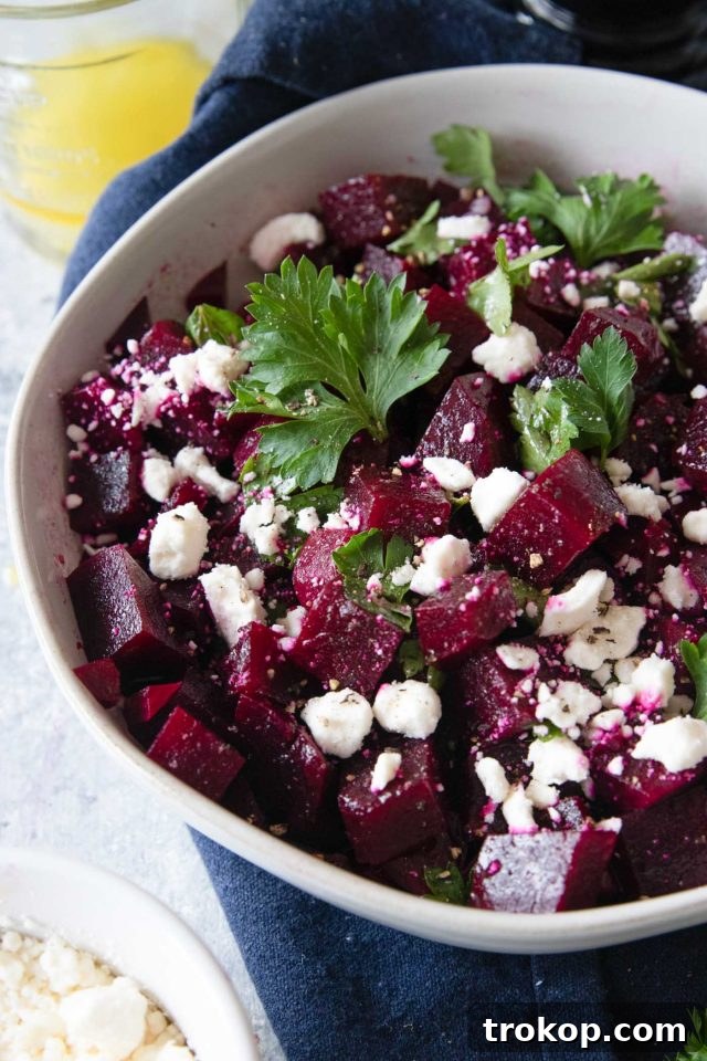 Vibrant Beetroot and Goat Cheese Salad 2 Close-up photo of a vibrant beetroot salad with goat cheese and fresh parsley, showcasing its rich colors and appetizing texture.