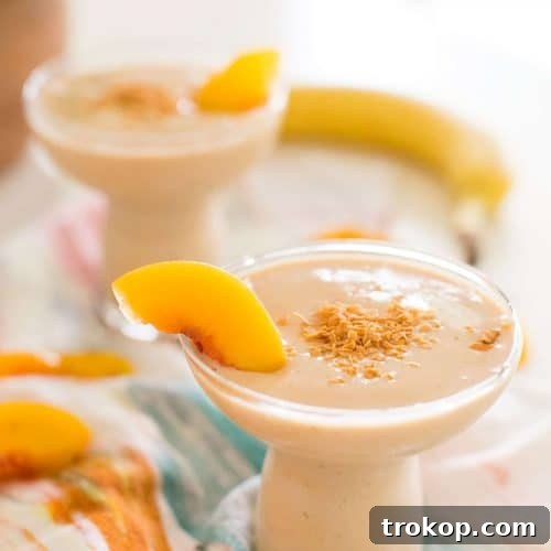close up of a banana peach in a smoothie with a banana on a table