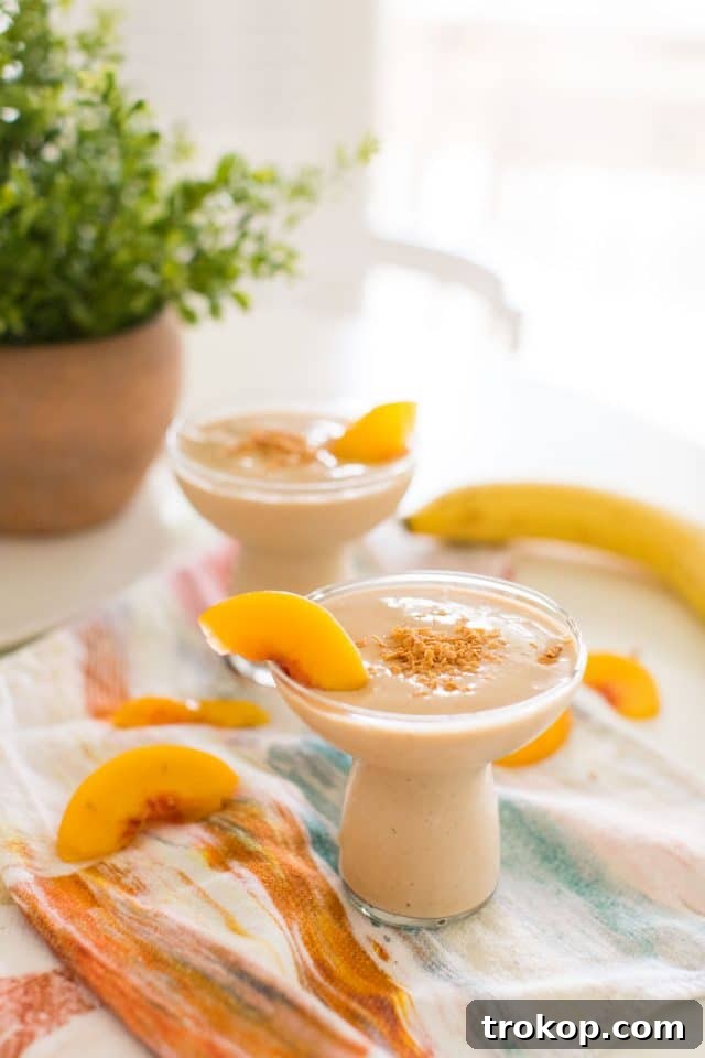 Overhead photo of a Banana Peach Smoothie and fresh ingredients
