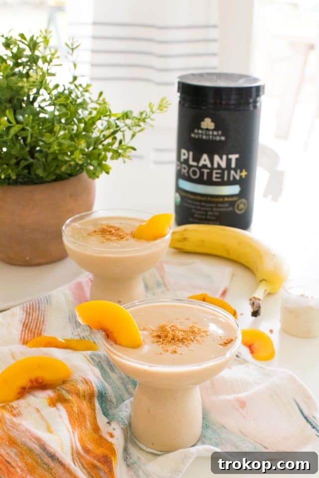 Two glasses of Banana Peach Smoothie on a wooden table