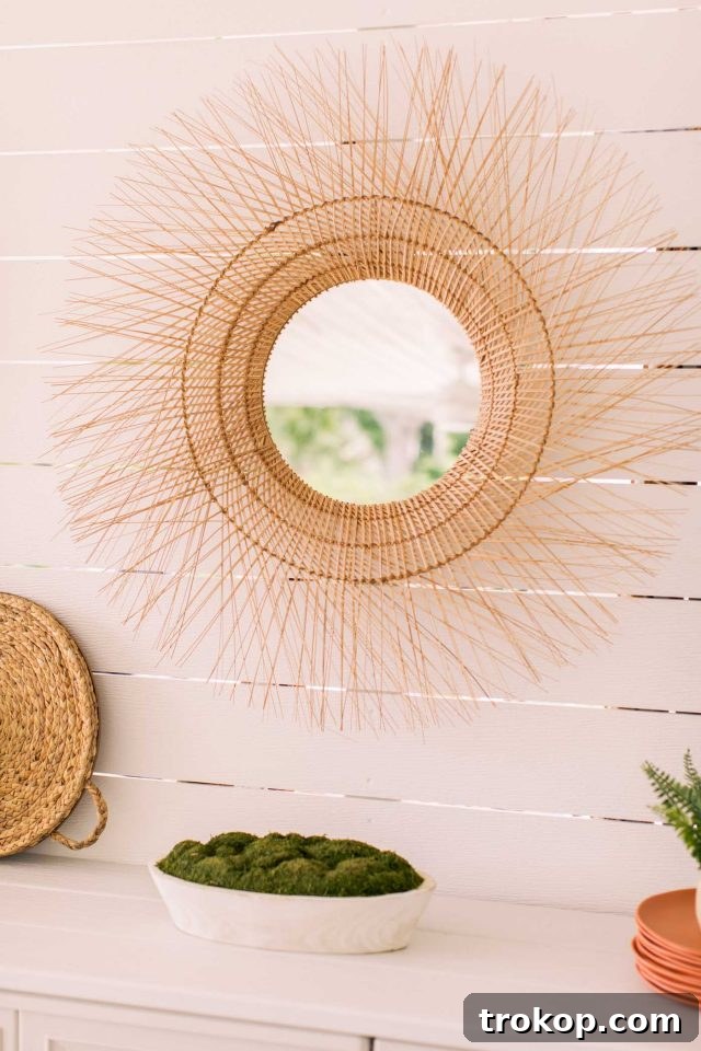 Rattan wicker mirror accentuating the shiplap wall, adding bohemian charm