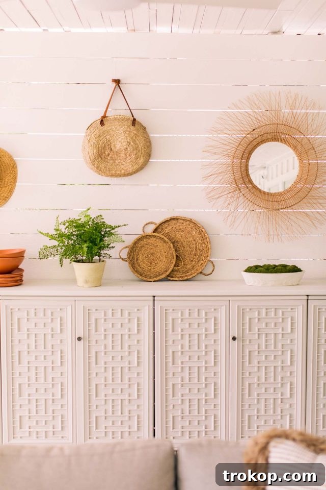 Mirrors and rattan weavings decorating the shiplap wall of the renovated patio