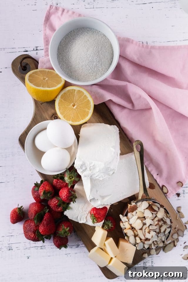 A flat lay photograph showcasing all the fresh, high-quality ingredients laid out to make a keto strawberry cheesecake, emphasizing their natural appeal.