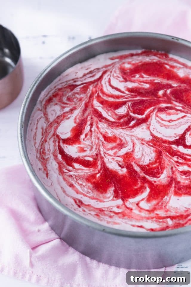 A close-up photo showcasing the beautiful strawberry swirl within the creamy low-carb cheesecake filling, highlighting the marbling effect.