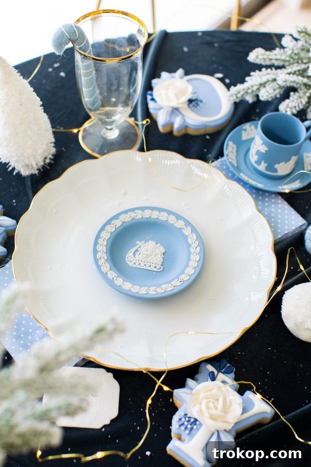 A close-up shot of a elegant polar blue table setting, showcasing intricate dinnerware and decor by Ashley Rose of Sugar & Cloth