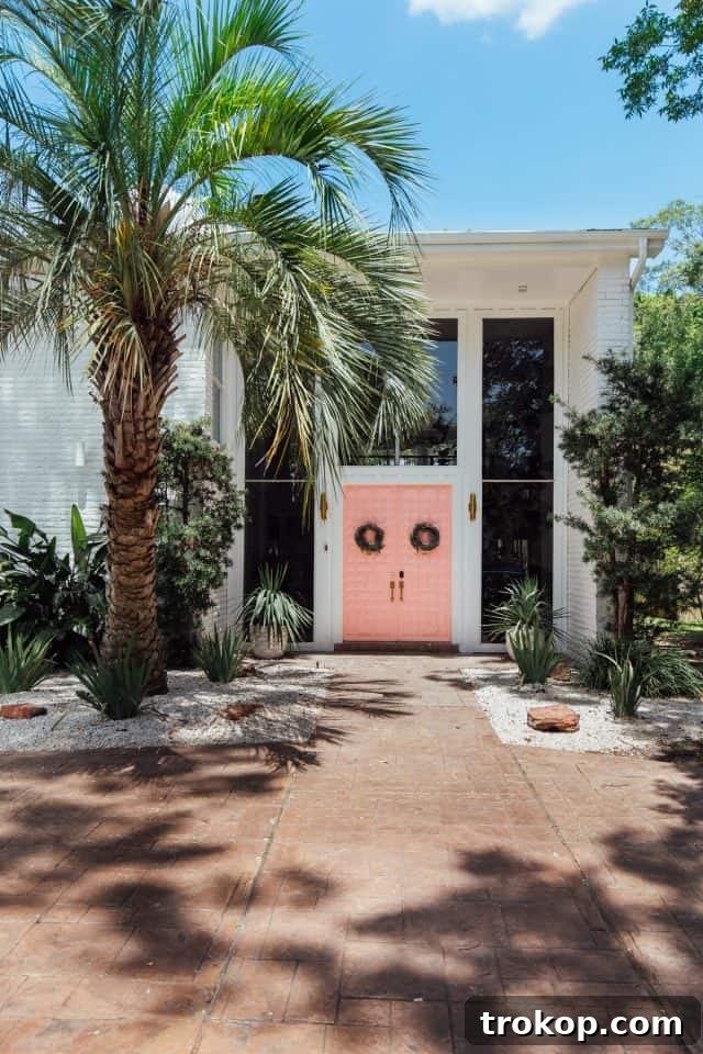 New Home Ahead 2 Charming pink front door and neatly paved driveway hinting at a beautifully renovated home