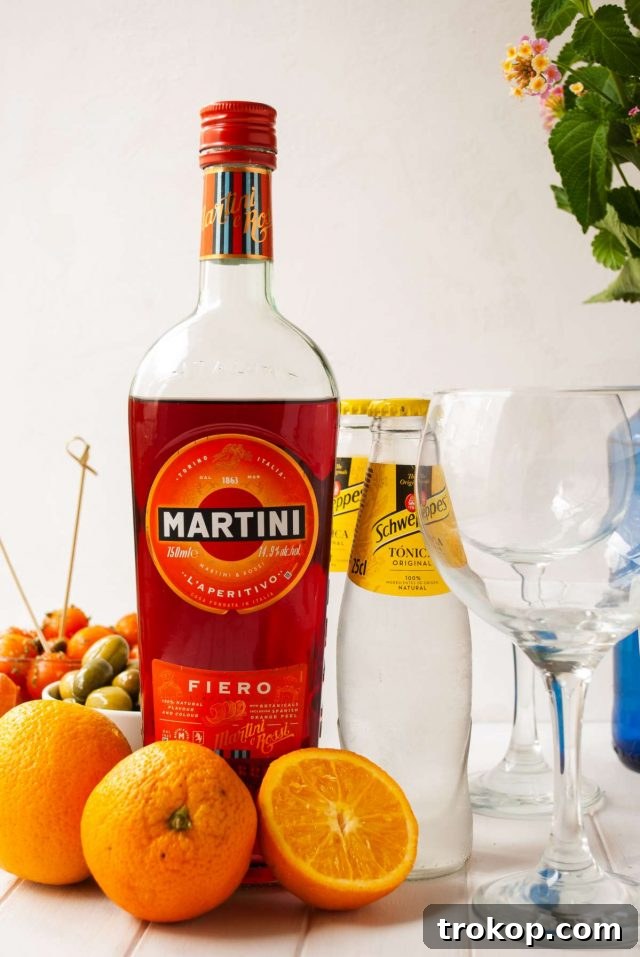 The Ultimate Martini Fiero Recipe 5 Fresh oranges, a bottle of Martini Fiero, tonic water, and a glass filled with ice.