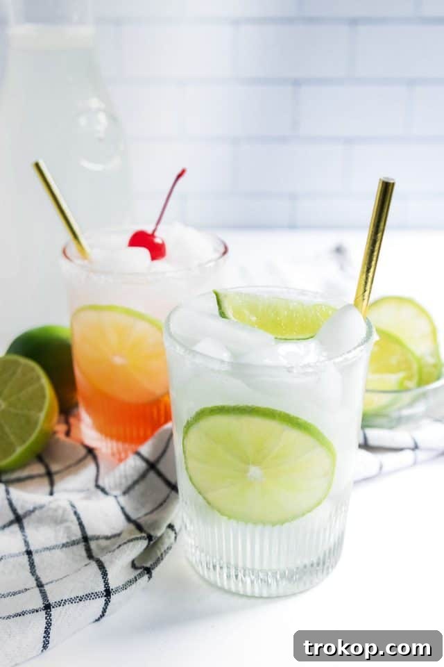 Refreshing Homemade Limeade 2 Freshly prepared homemade limeade drink with a cherry limeade variation, garnished with a lime slice and a cherry.