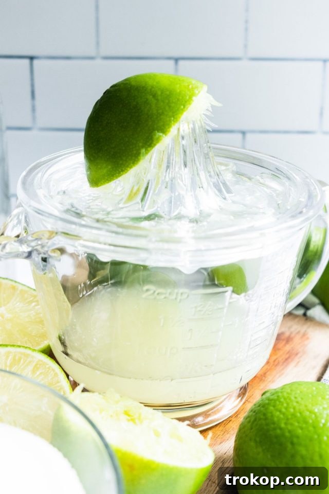 Refreshing Homemade Limeade 6 A close-up of a glass filled with freshly squeezed lime juice, ready for making limeade.