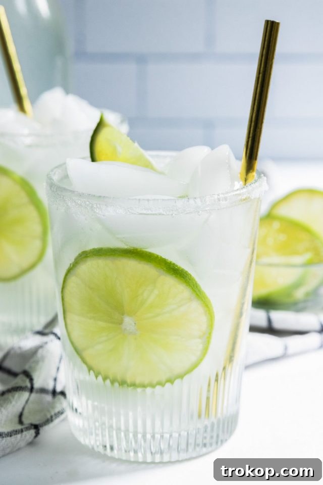 Refreshing Homemade Limeade 7 A single serving of homemade limeade juice, poured over ice in a glass, ready to be enjoyed.