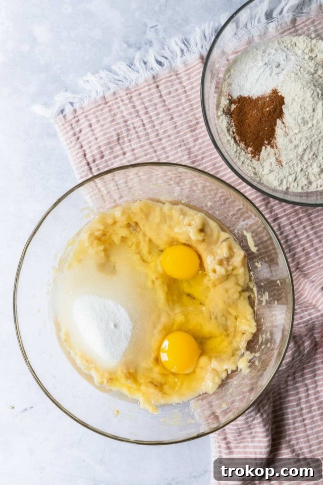 Mixing bowl with wet ingredients (mashed bananas, sugar, eggs, oil, vanilla).