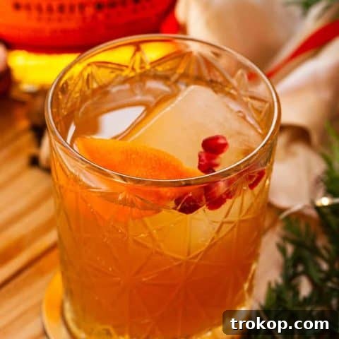 Heirloom Christmas Recipes 9 A beautifully presented Christmas Old Fashioned cocktail, garnished with orange peel and pomegranate seeds.