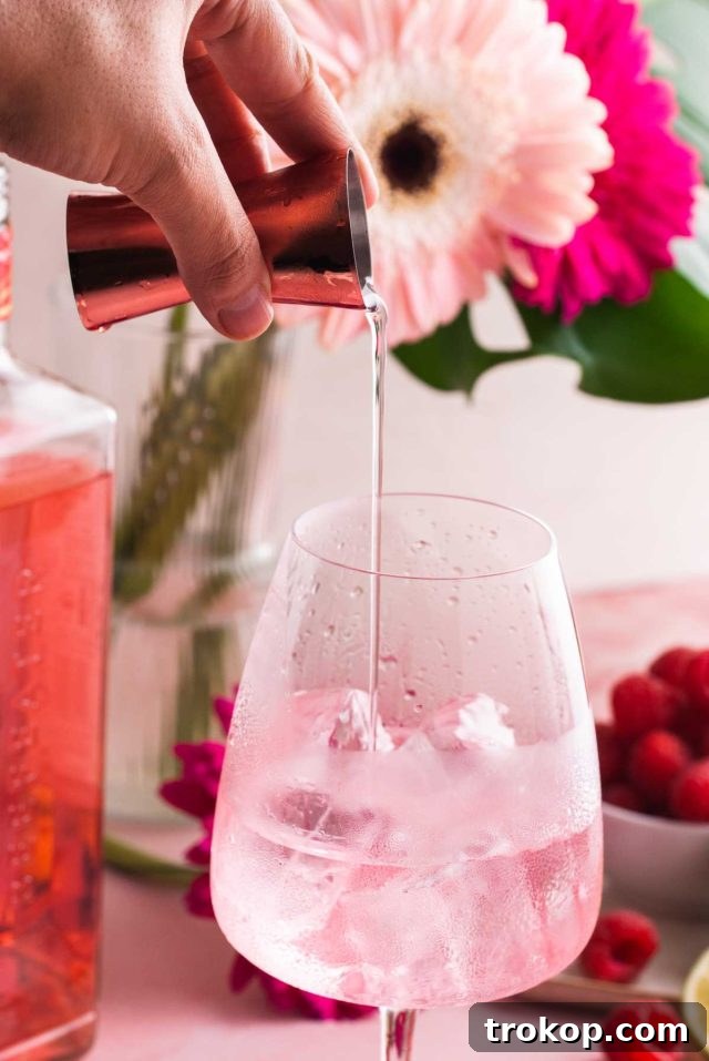 Crafting the Perfect Pink Gin Spritz 4 what can you mix with gin - pouring the ingredients in a serving glass