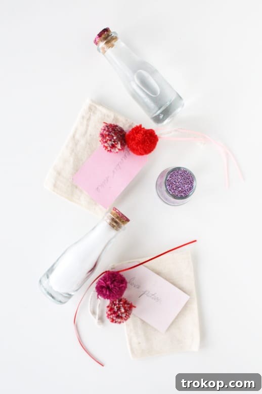 Tall apothecary bottle filled with bath salts and a glitter-dipped cork, part of a DIY love potion bath set