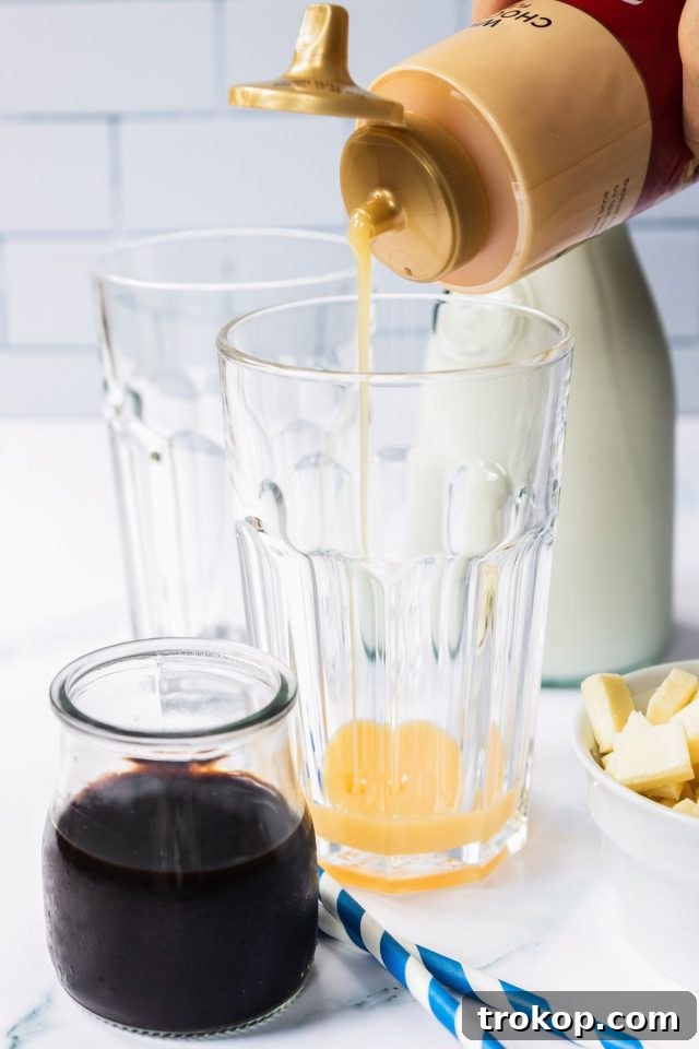 Pouring white chocolate syrup into a glass