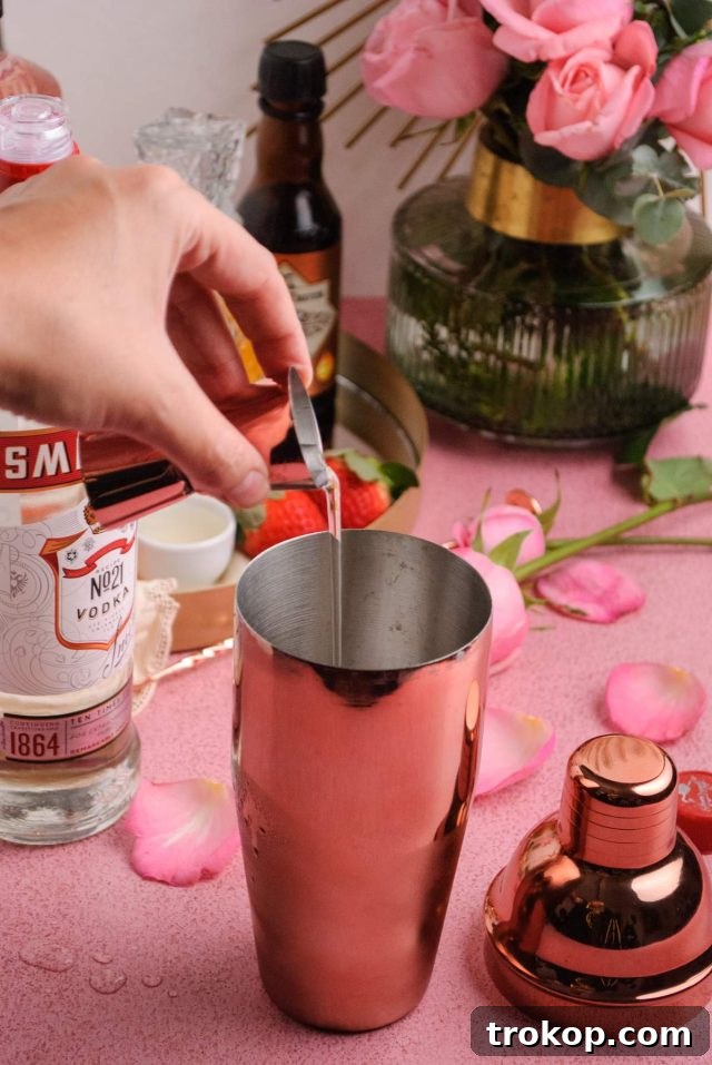 Blushing Rose Martini 8 rose syrup cocktail - pouring ingredients in a cocktail shaker