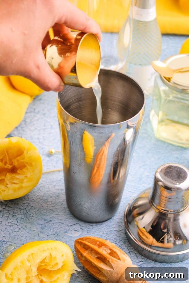 French 76 with vodka - image of a cocktail mixer being used to pour fresh lemon juice, indicating the preparation stage.