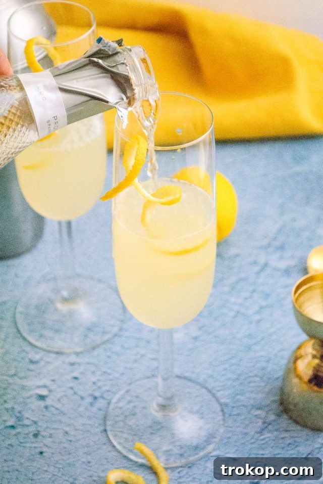 How to make a French 75 - image showing Champagne being poured into a serving glass, the final step in preparing the French 76 cocktail.
