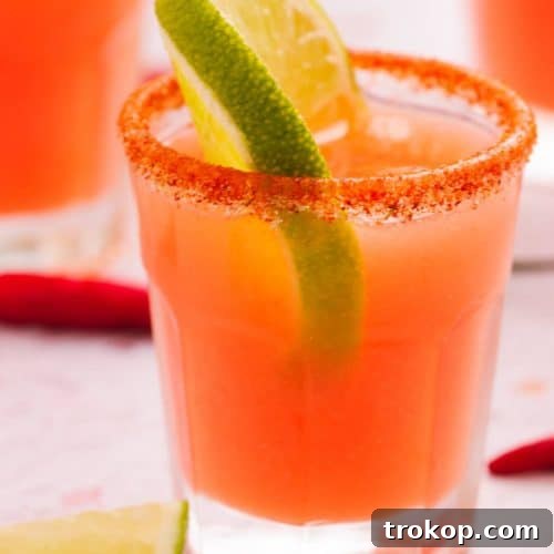 A single serving of a Mexican candy shot, garnished with lime.