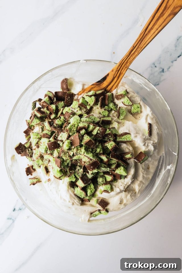 The vibrant green mint cream cheese mixture combined with whipped cream and chopped Aero Mint chocolate chunks