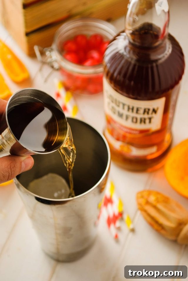 adding southern comfort in a cocktail shaker for the alabama slammer