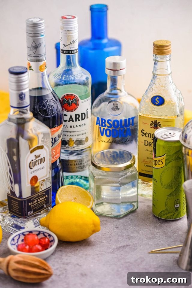 Assortment of spirits and fresh ingredients laid out to make a Blue Motorcycle cocktail