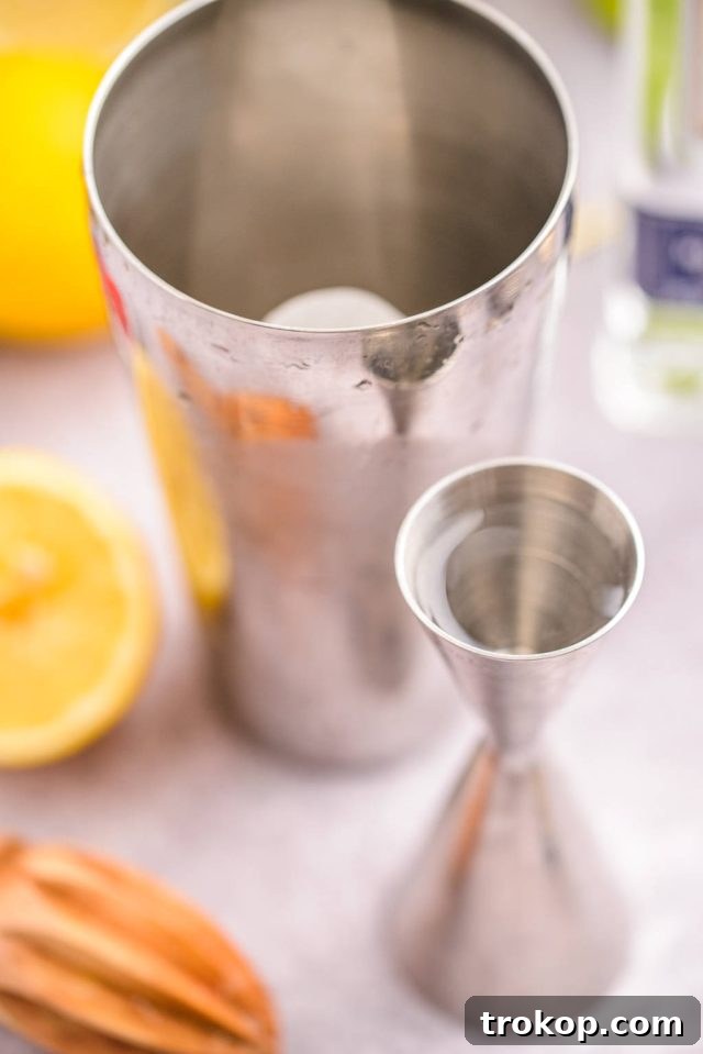 A cocktail shaker filled with ice, ready to mix a Blue Motorcycle cocktail.
