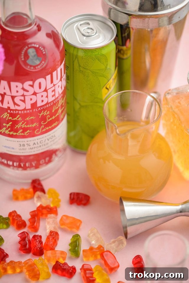 Ingredients laid out for making the Gummy Bear Shots, including bottles of liquor, juice, and gummy bears