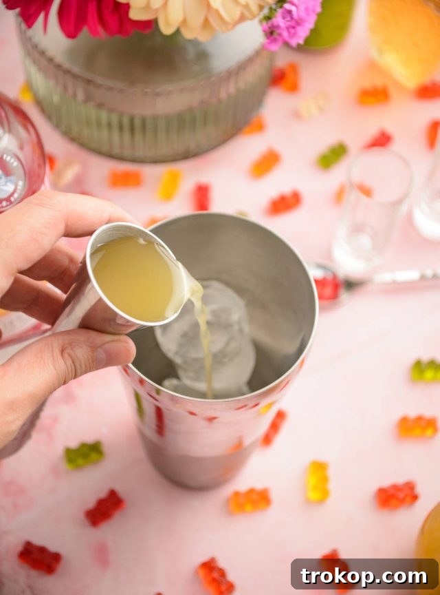 Ice cubes and liquid ingredients inside a cocktail shaker, ready to be mixed for Gummy Bear Shots