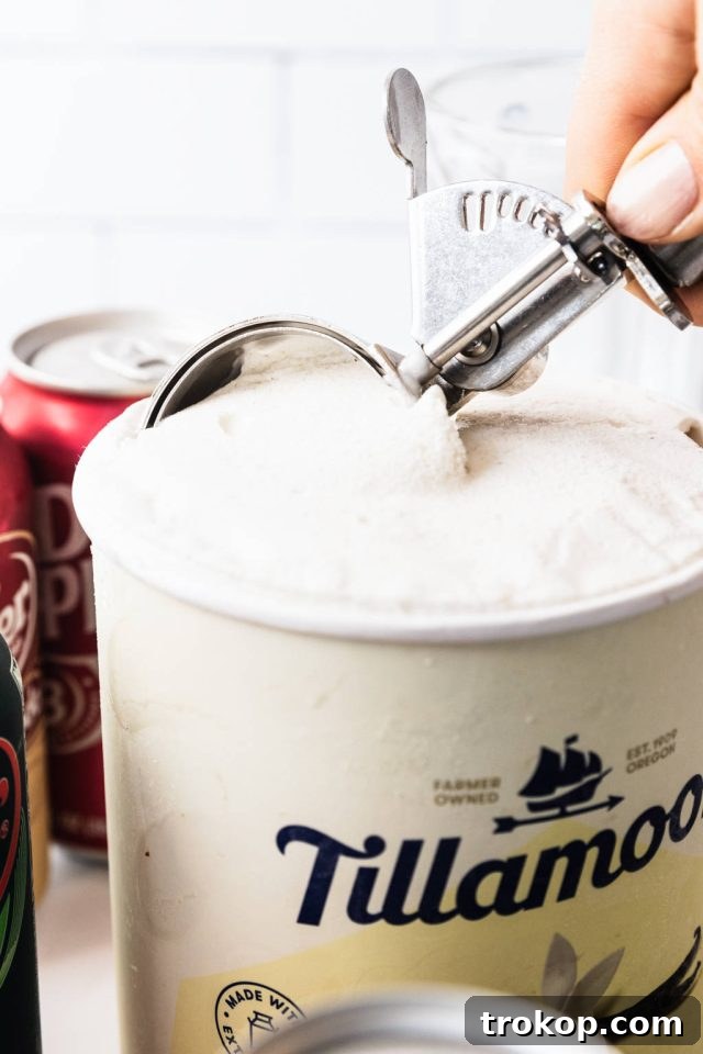 Decadent Homemade Dr. Pepper Vanilla Float 5 Scooping vanilla ice cream into a glass for the Dr. Pepper Vanilla Float, showing the initial step of assembly