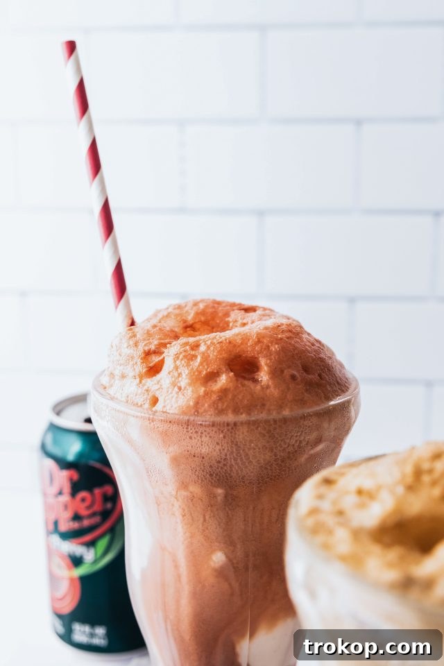 Decadent Homemade Dr. Pepper Vanilla Float 7 Close-up photo of a Dr. Pepper Vanilla Float, showing the layers of ice cream, soda, and whipped cream, possibly with a cherry garnish