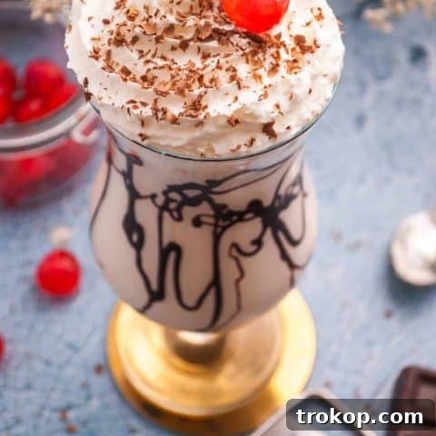 Bushwacker Recipe: Make Your Own Cream of Coconut Cocktail 9 A beautifully presented glass of the best Bushwacker cocktail with a maraschino cherry on top, whipped cream, and chocolate shavings, ready to drink.