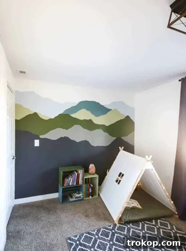 Mountain mural accent wall in a toddler boy's room