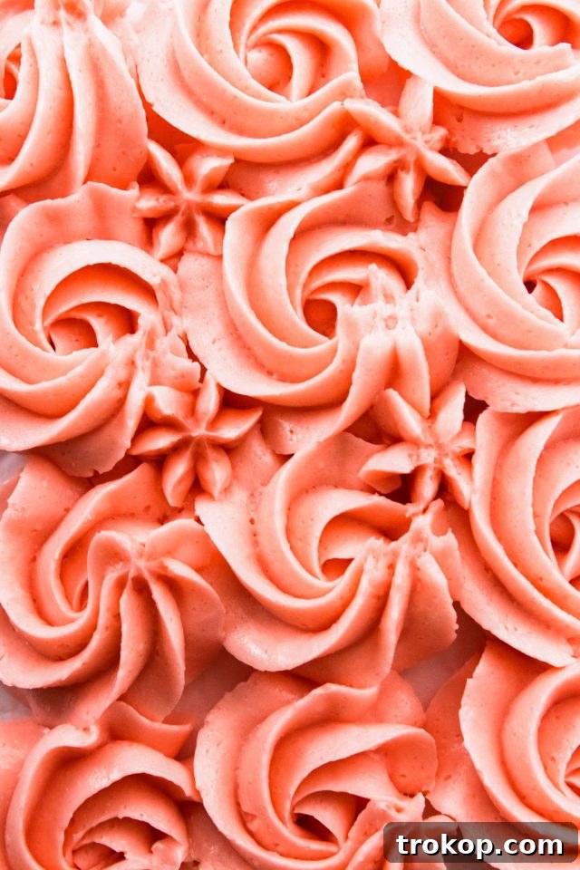 Silky Smooth Italian Meringue Buttercream Frosting 12 Beautifully piped pink Italian Meringue Buttercream frosting on a cake, showcasing its smooth texture.